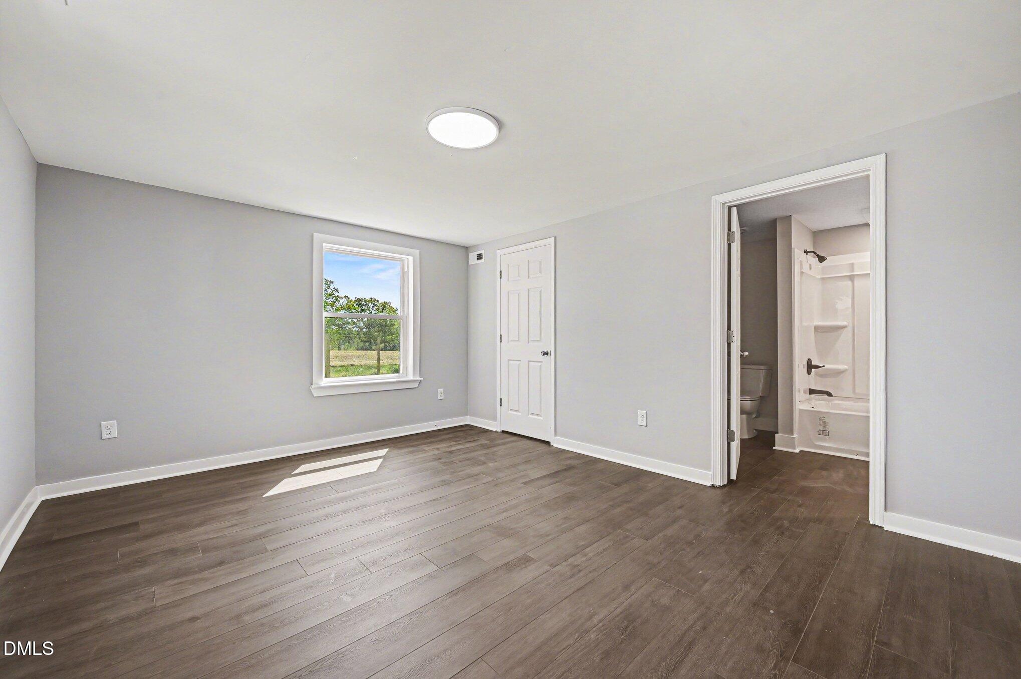 1325 Charlie Carr Road Roxboro, NC 27574 - Photo 24 of 31 an empty room with wooden floor and windows