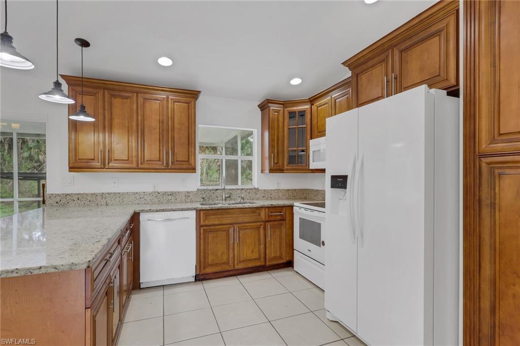 190 15th Street Southwest Naples, FL 34117 - Photo 4 of 26 a kitchen with stainless steel appliances granite countertop a refrigerator and a sink