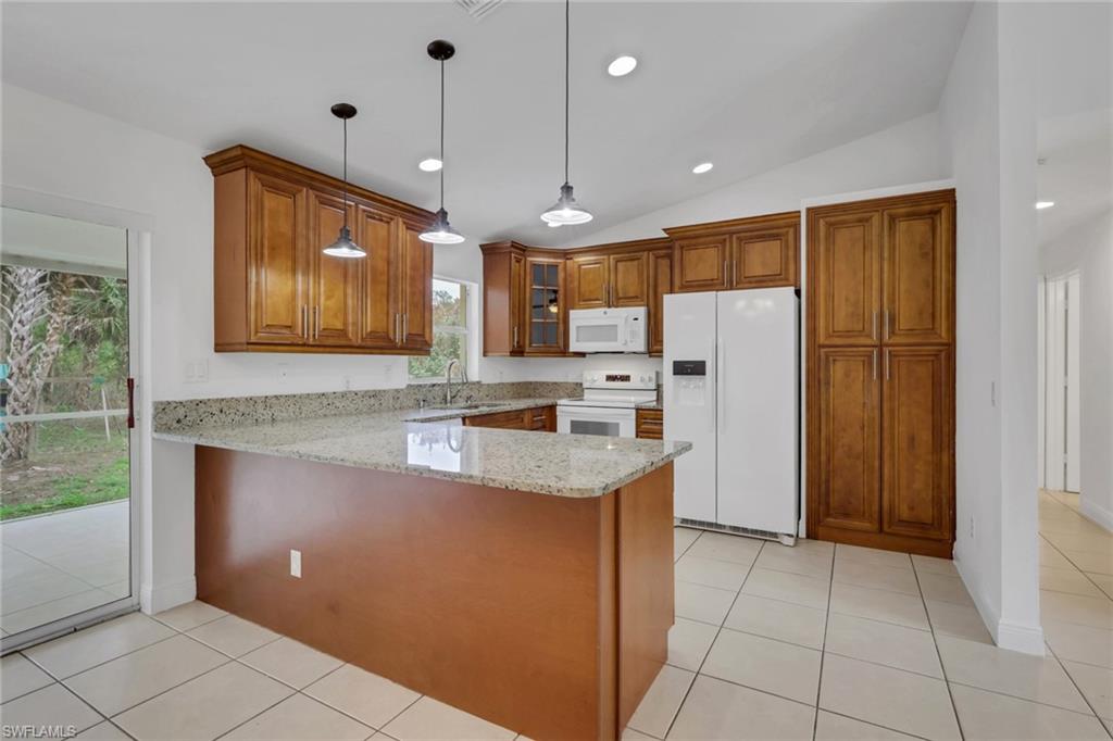 190 15th Street Southwest Naples, FL 34117 - Photo 7 of 26 a kitchen with stainless steel appliances granite countertop a refrigerator a sink and a stove