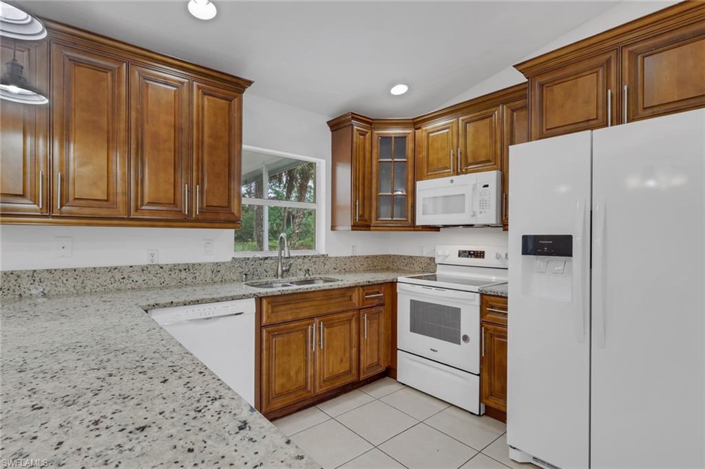 190 15th Street Southwest Naples, FL 34117 - Photo 8 of 26 a kitchen with stainless steel appliances granite countertop a stove a sink and a refrigerator