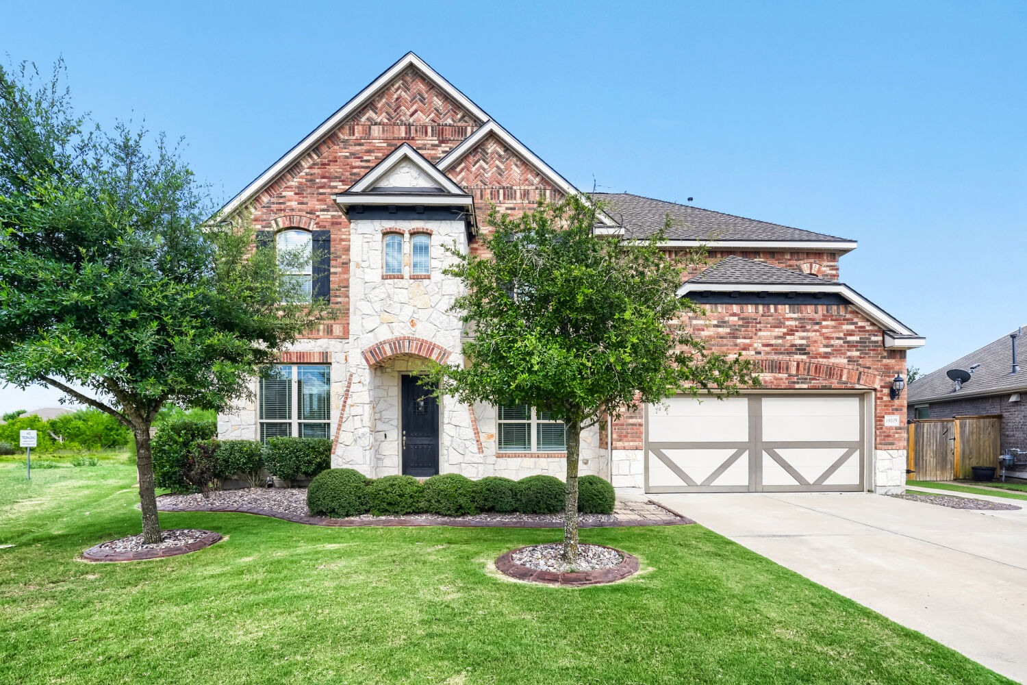 Stately brick and stone façade with detailed landscaping