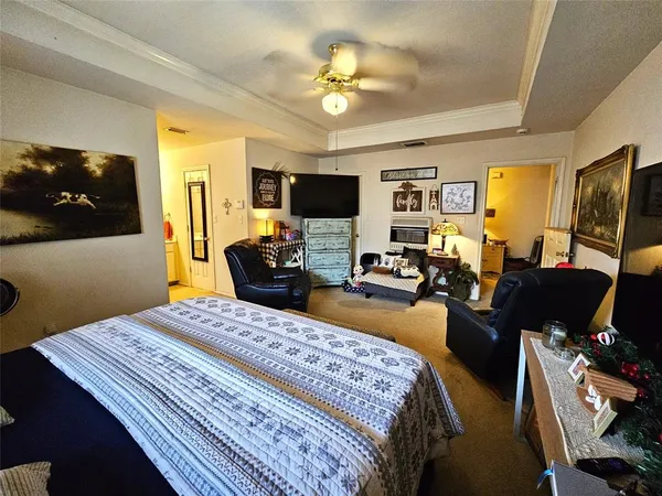 a bedroom with a bed a couch and a flat screen tv