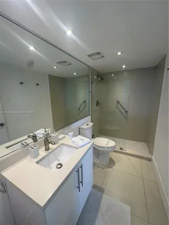 a bathroom with a double vanity sink toilet and shower