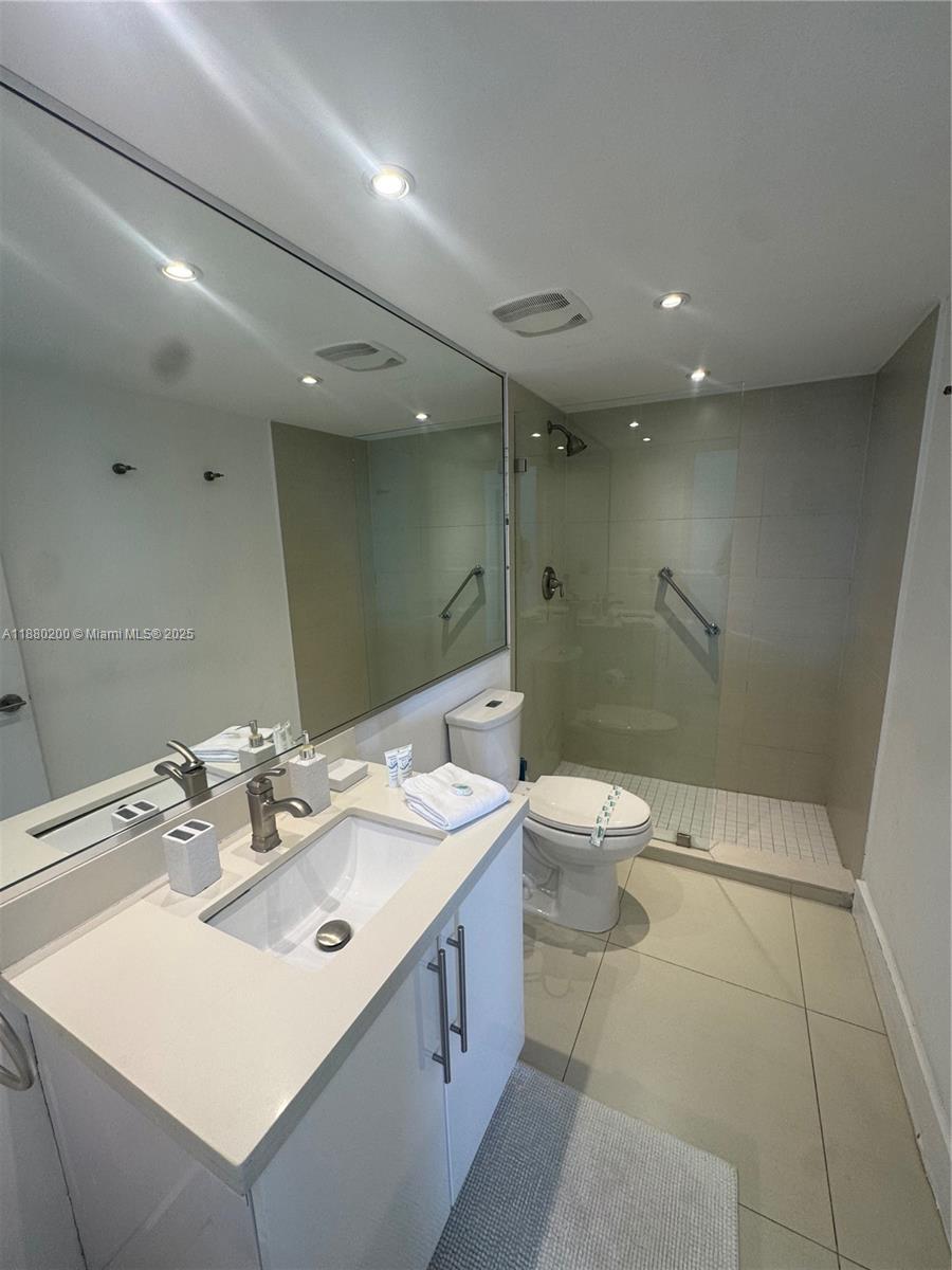 5151 Collins Avenue, Unit 923 Miami Beach, FL 33140 - Photo 14 of 32 a bathroom with a double vanity sink toilet and shower