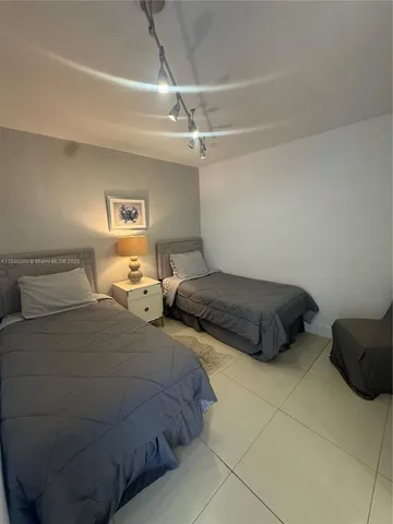 a bedroom with two bed and a ceiling fan
