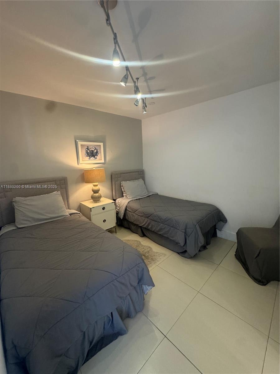 5151 Collins Avenue, Unit 923 Miami Beach, FL 33140 - Photo 15 of 32 a bedroom with two bed and a ceiling fan