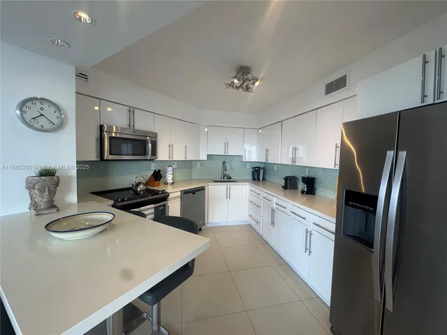 a kitchen with stainless steel appliances a stove refrigerator sink and microwave