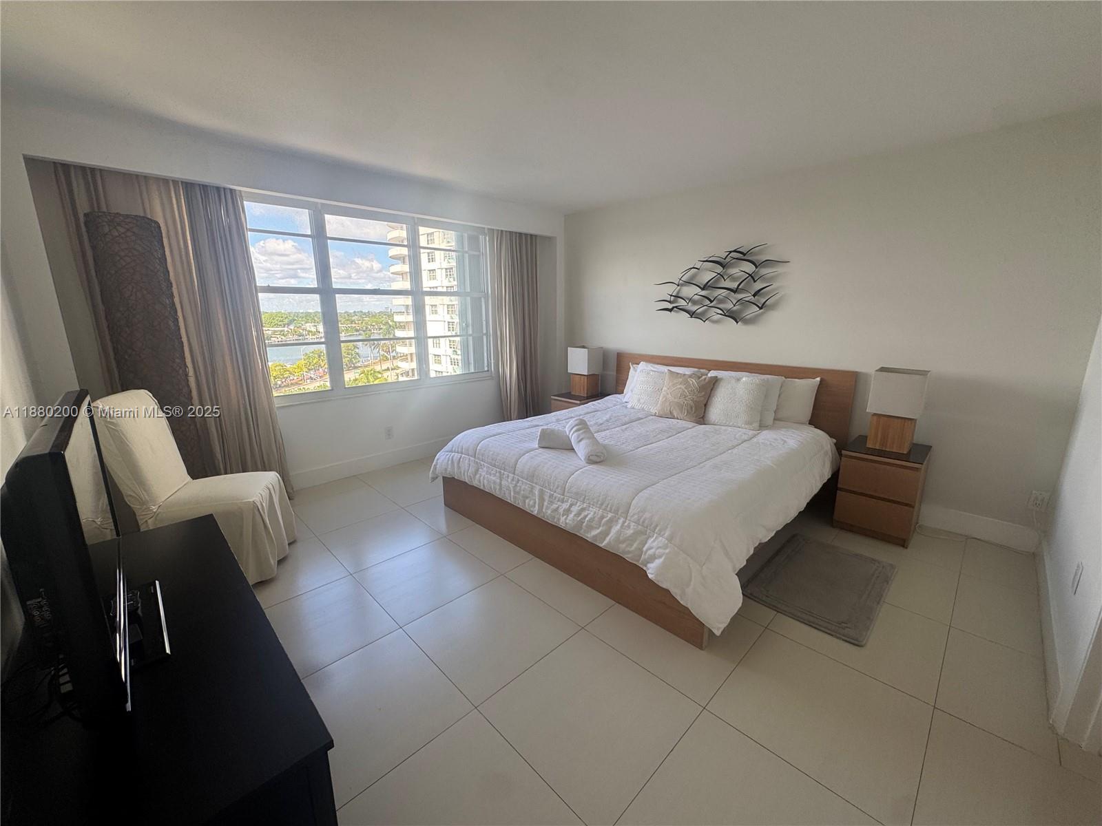 5151 Collins Avenue, Unit 923 Miami Beach, FL 33140 - Photo 7 of 32 a bedroom with a bed and a couch next to a window