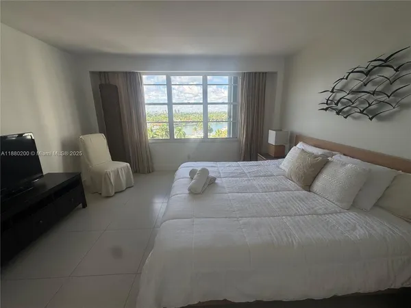 a bed sitting in a bedroom next to a window with lamp