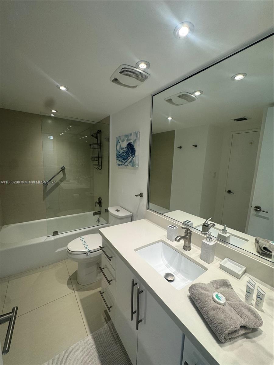 5151 Collins Avenue, Unit 923 Miami Beach, FL 33140 - Photo 10 of 32 a bathroom with a double vanity sink mirror double and toilet