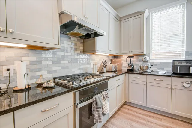 a kitchen with stainless steel appliances a sink a stove and cabinets