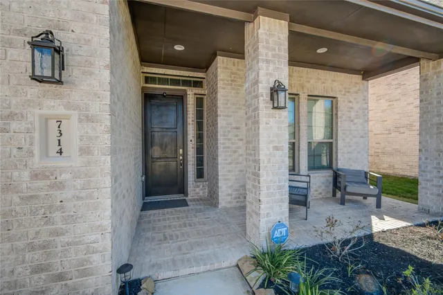 a front view of a house with a potted plant and a shower