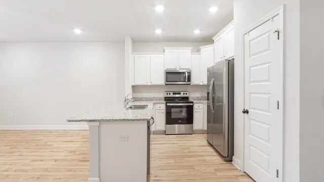 a kitchen with stainless steel appliances a refrigerator and a stove top oven