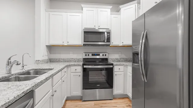 a kitchen with stainless steel appliances granite countertop a sink stove and refrigerator