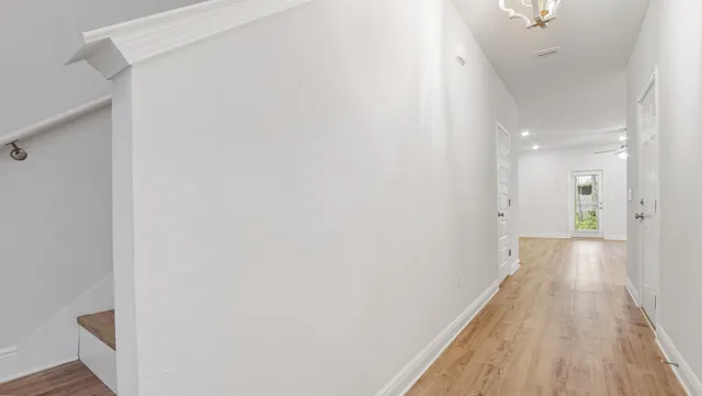 a view of a hallway with wooden floor