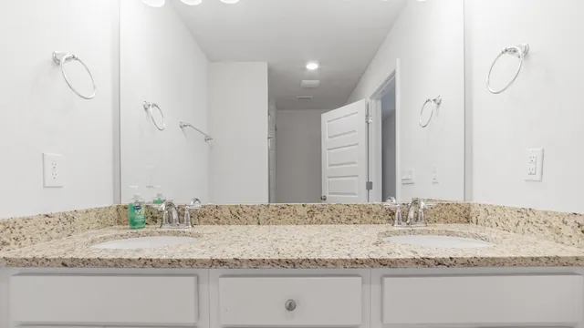 a bathroom with a granite countertop sink and mirror
