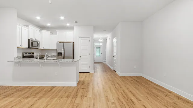 a view of a kitchen with a sink and wooden floor