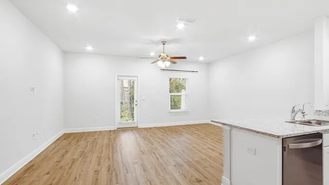 a view of empty room with wooden floor and window