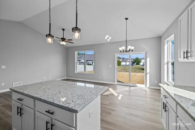 an empty room with windows and ceiling fan