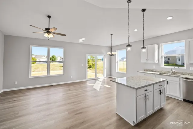 a kitchen with a stove a sink a window and chairs