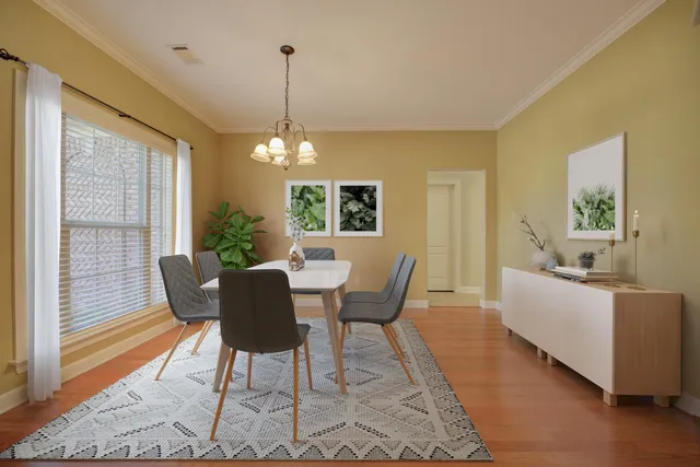 a dining room with furniture a chandelier and wooden floor
