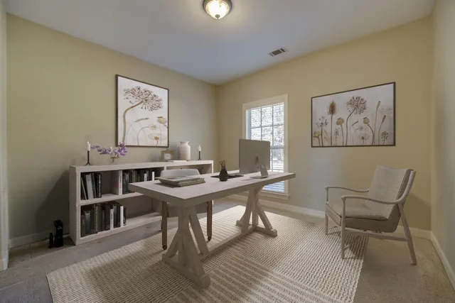 a view of a workspace with furniture and a window