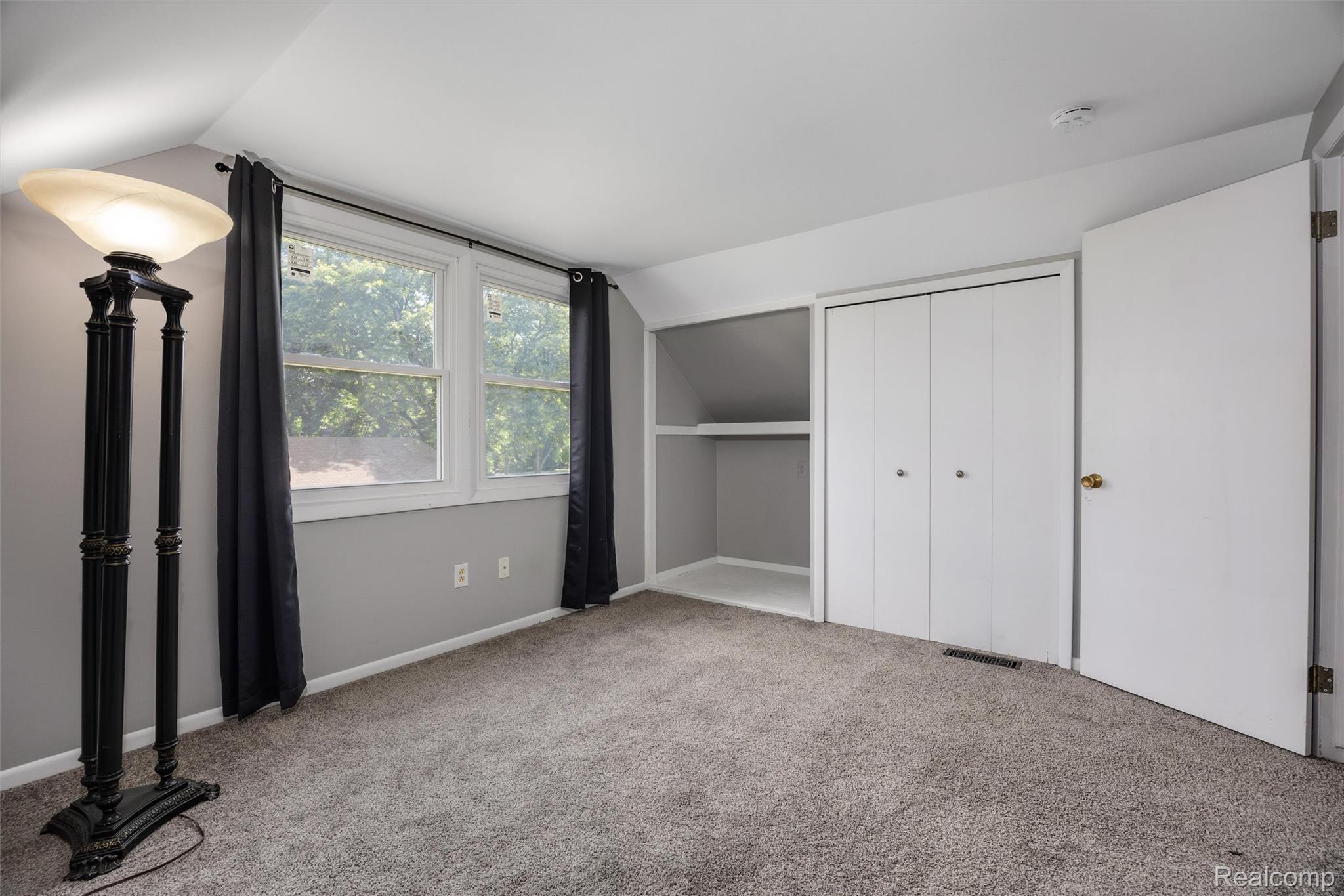 4942 Butler Drive Troy, MI 48085 - Photo 28 of 33 Carpeted room featuring dual windows with dark draperies, a bi-fold closet, and a built-in shelving unit
