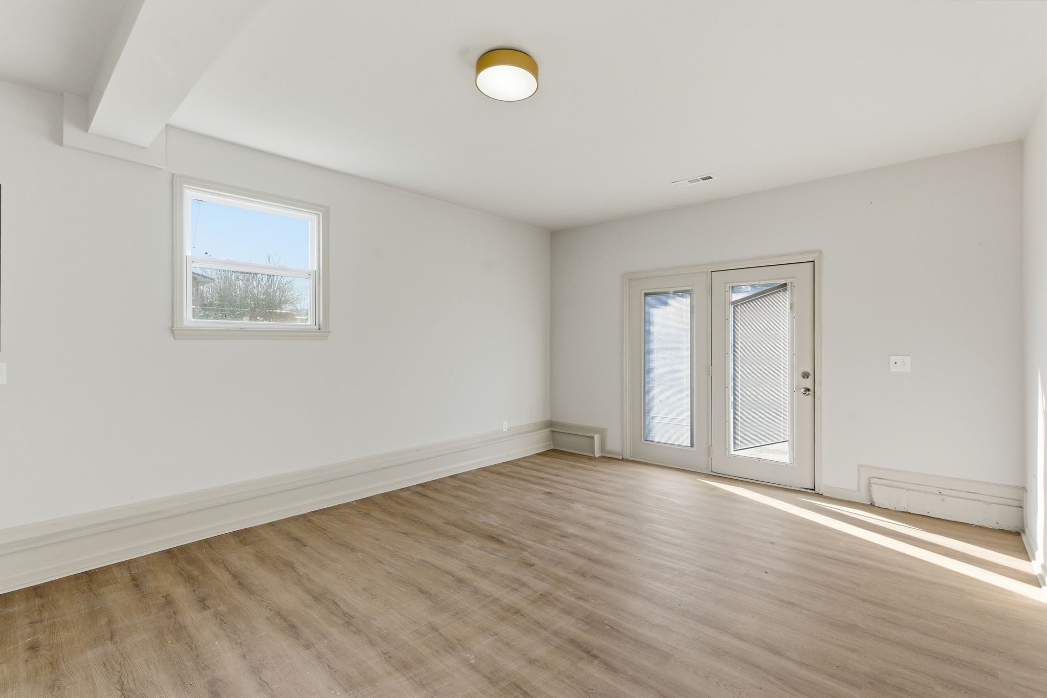 503 South Ramsey Street Manchester, TN 37355 - Photo 15 of 29 an empty room with wooden floor and windows