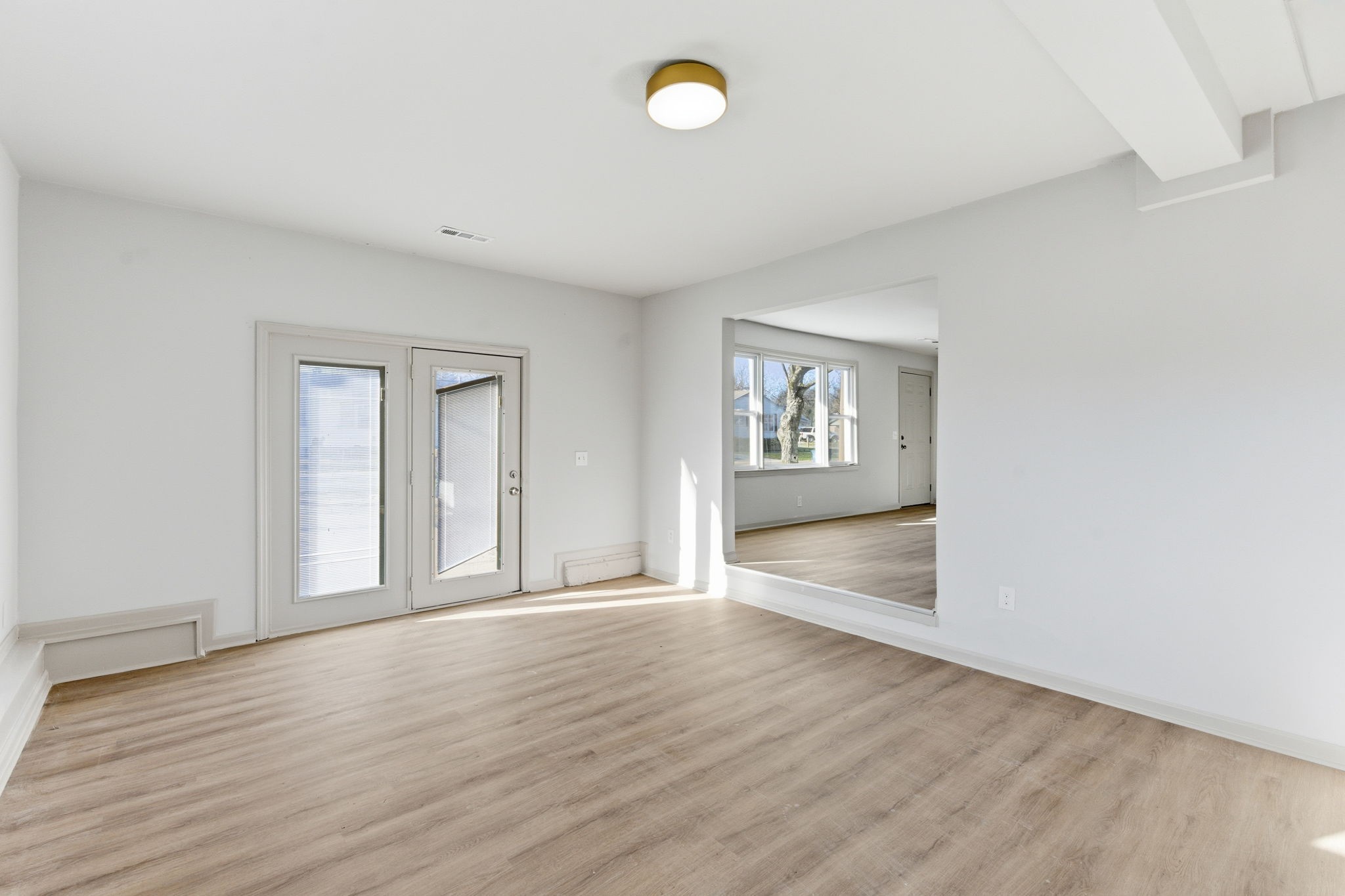 503 South Ramsey Street Manchester, TN 37355 - Photo 8 of 29 a view of an empty room with a window and wooden floor