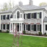 a front view of a house with a yard and green space