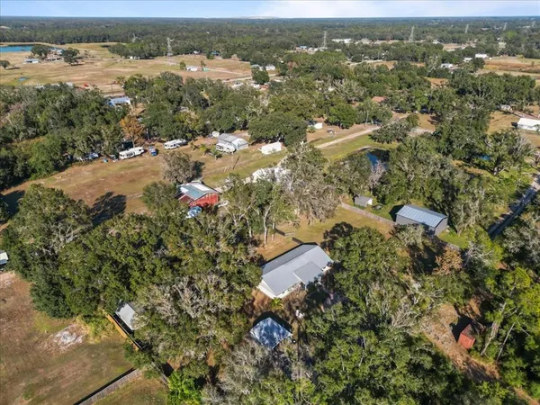 an aerial view of residential houses with outdoor space and trees