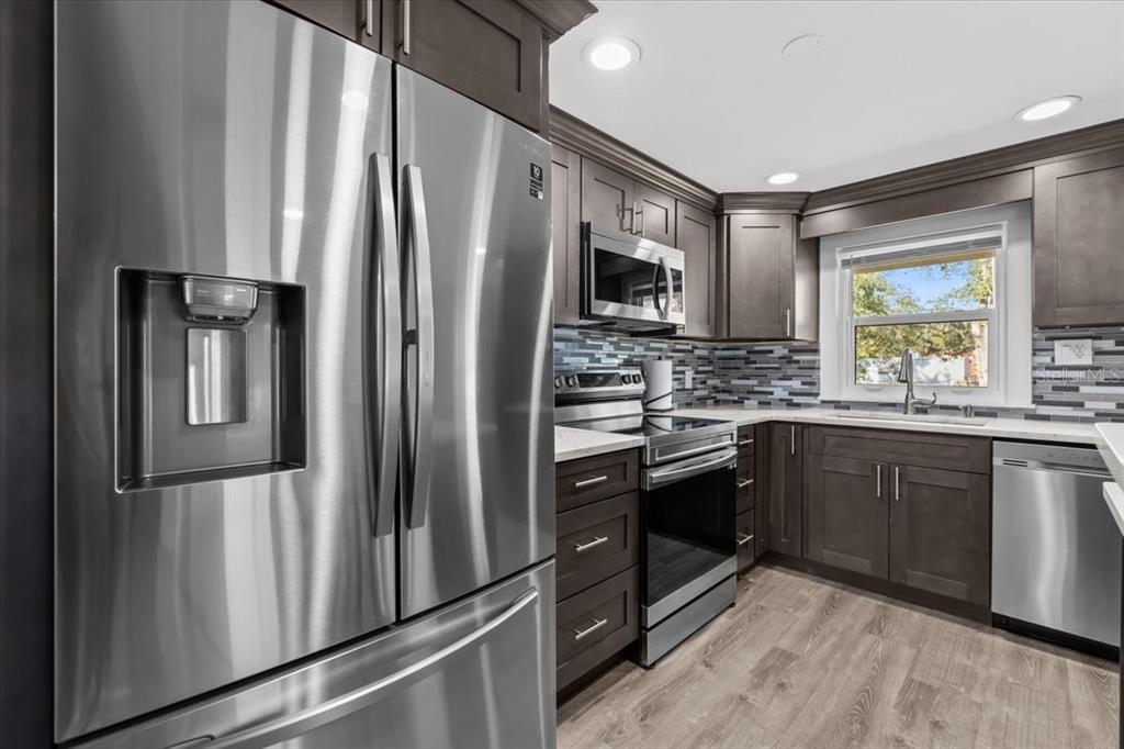 4805 Cooper Road Plant City, FL 33565 - Photo 40 of 45 a kitchen with stainless steel appliances granite countertop a refrigerator stove and sink
