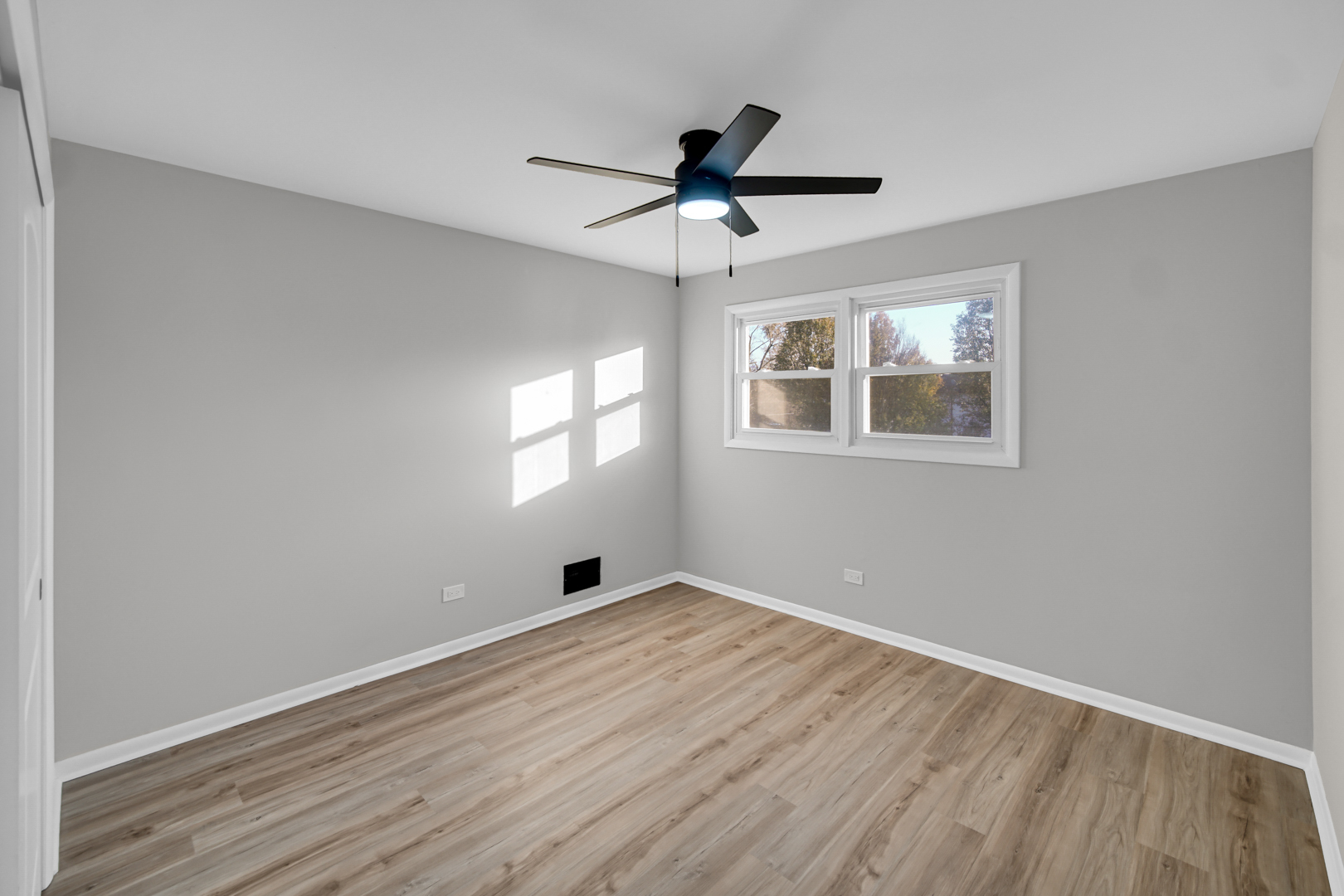 6827 Sussex Road Tinley Park, IL 60477 - Photo 17 of 27 a view of an empty room with wooden floor and a window