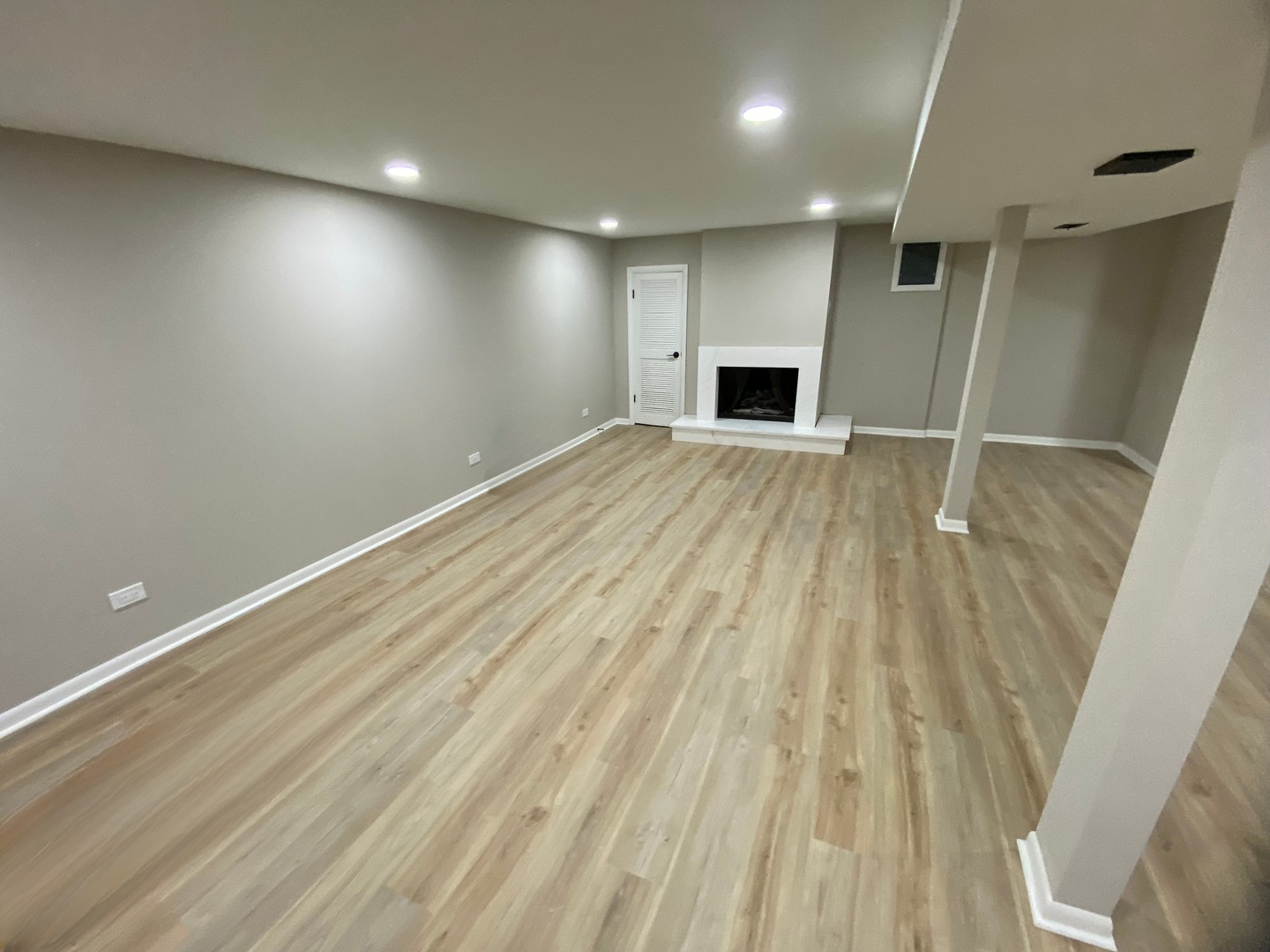 6827 Sussex Road Tinley Park, IL 60477 - Photo 21 of 27 an empty room with wooden floor and a fireplace