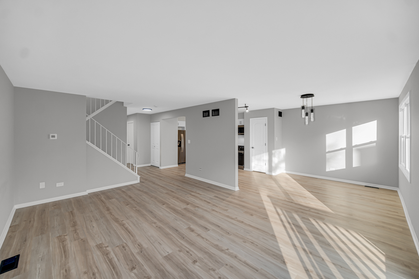 6827 Sussex Road Tinley Park, IL 60477 - Photo 8 of 27 a view of a big room with wooden floor and windows