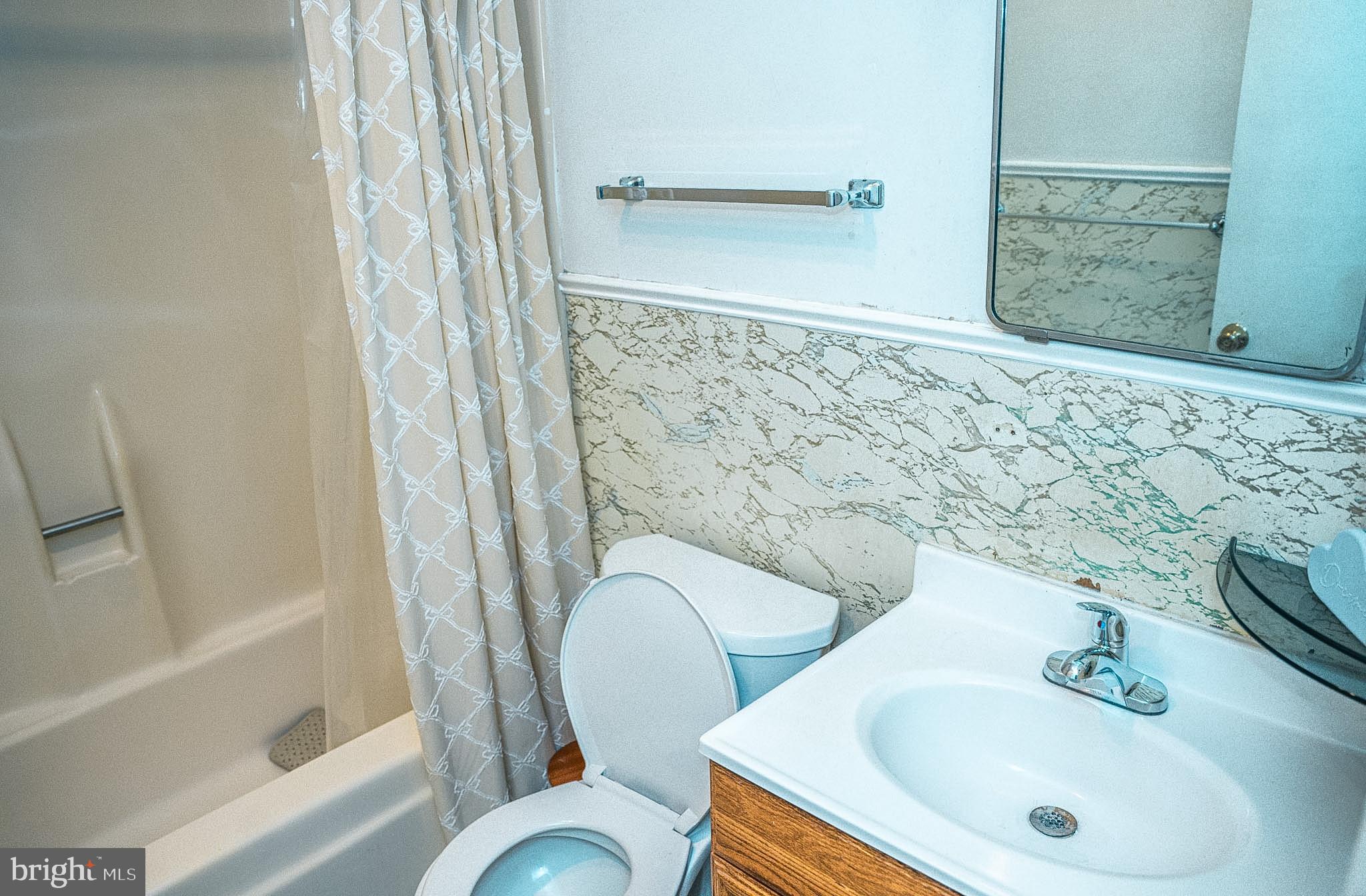 6304 Somerset Road Riverdale, MD 20737 - Photo 14 of 22 a bathroom with a sink and mirror with bathtub