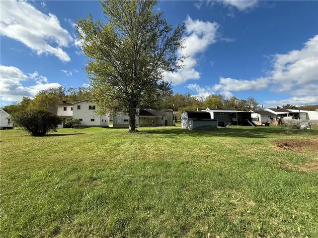 a view of yard with green space and car parked