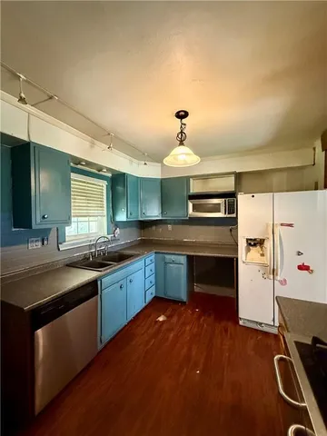 a view of a kitchen with stainless steel appliances wooden floor and window