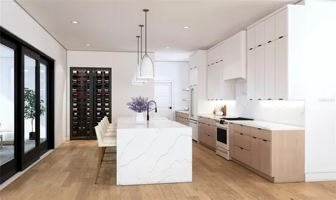 a large white kitchen with stainless steel appliances