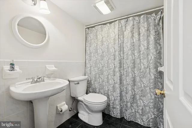 a bathroom with a sink a toilet and a mirror