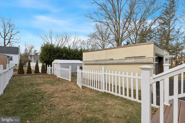 a white house that has tree in front of it