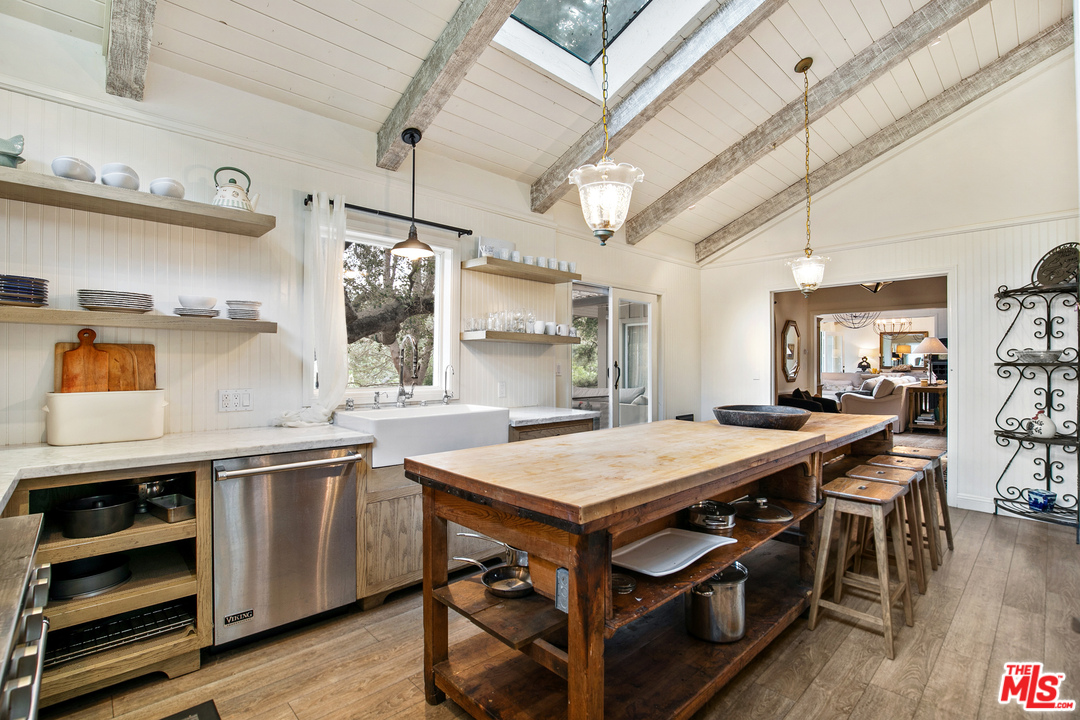 6133 Ramirez Canyon Road Malibu, CA 90265 - Photo 14 of 53 a kitchen with stainless steel appliances granite countertop a sink and wooden floor