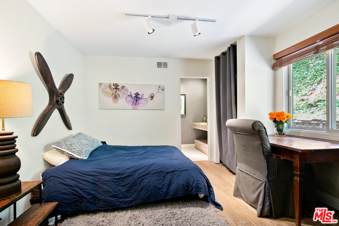 6133 Ramirez Canyon Road Malibu, CA 90265 - Photo 21 of 53 a bedroom with a bed and wooden floor