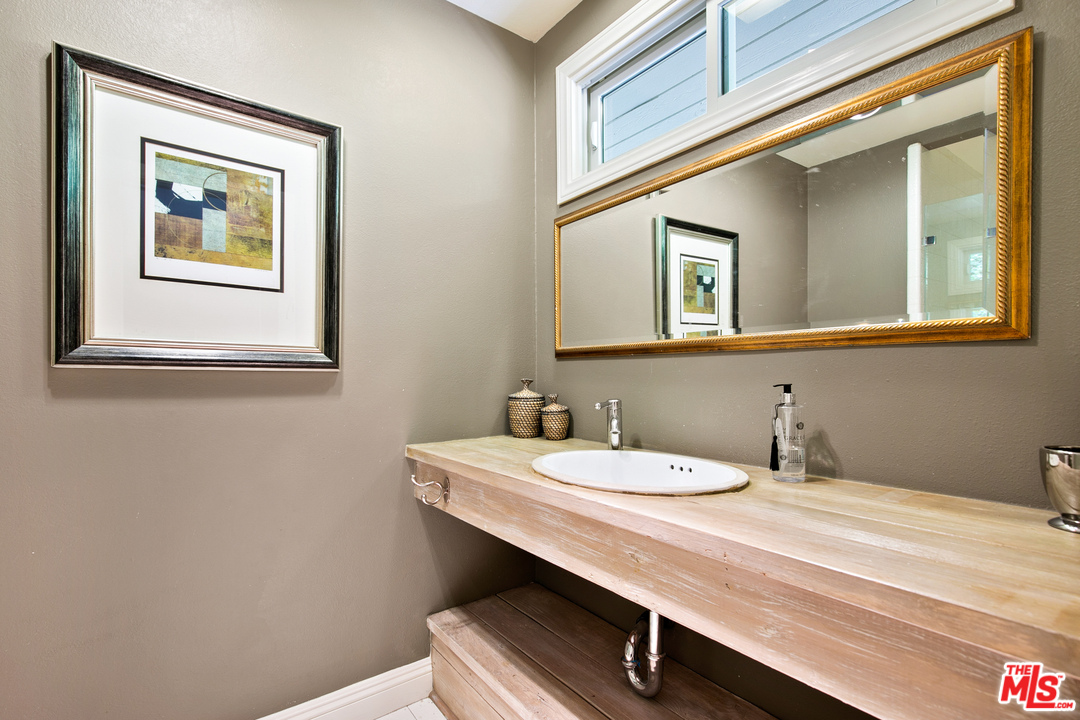 6133 Ramirez Canyon Road Malibu, CA 90265 - Photo 22 of 53 a bathroom with a sink a mirror and a toilet