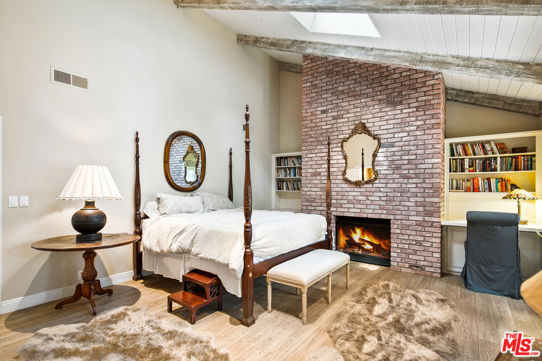 6133 Ramirez Canyon Road Malibu, CA 90265 - Photo 25 of 53 a bed sitting in a room next to a fireplace