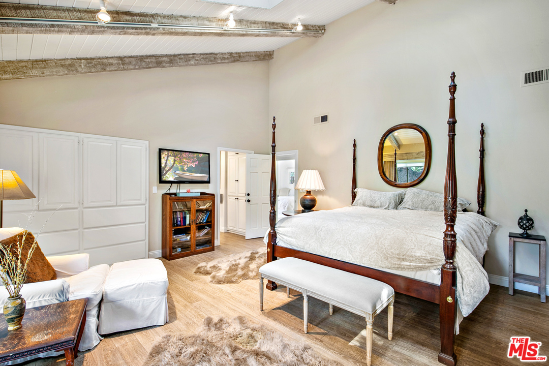 6133 Ramirez Canyon Road Malibu, CA 90265 - Photo 26 of 53 a bedroom with a bed a mirror and lamp on desk