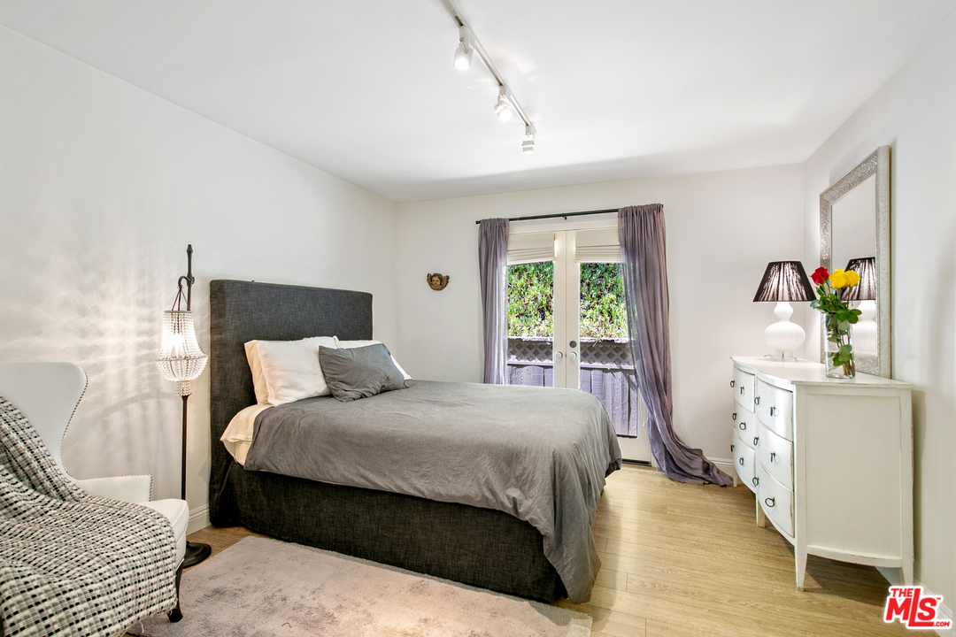 6133 Ramirez Canyon Road Malibu, CA 90265 - Photo 30 of 53 a bedroom with a bed and wooden floor