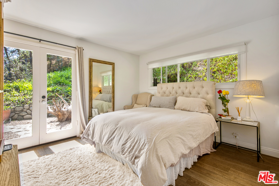 6133 Ramirez Canyon Road Malibu, CA 90265 - Photo 33 of 53 a bedroom with a bed and large windows