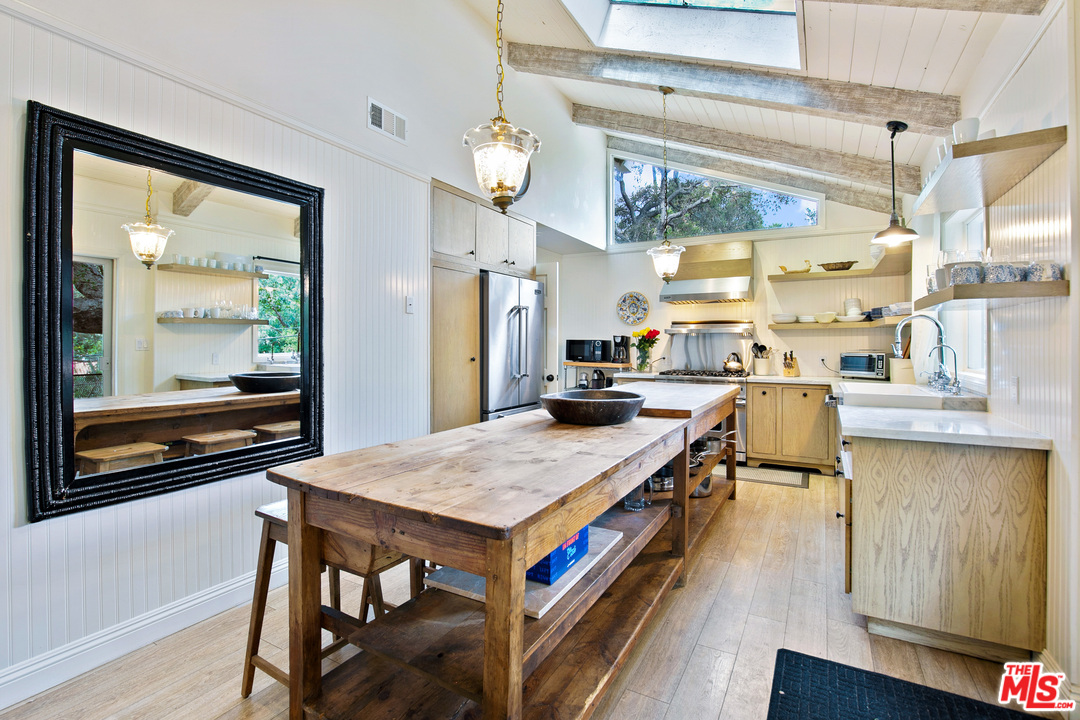 6133 Ramirez Canyon Road Malibu, CA 90265 - Photo 5 of 53 a living room with stainless steel appliances kitchen island granite countertop furniture and a wooden floor