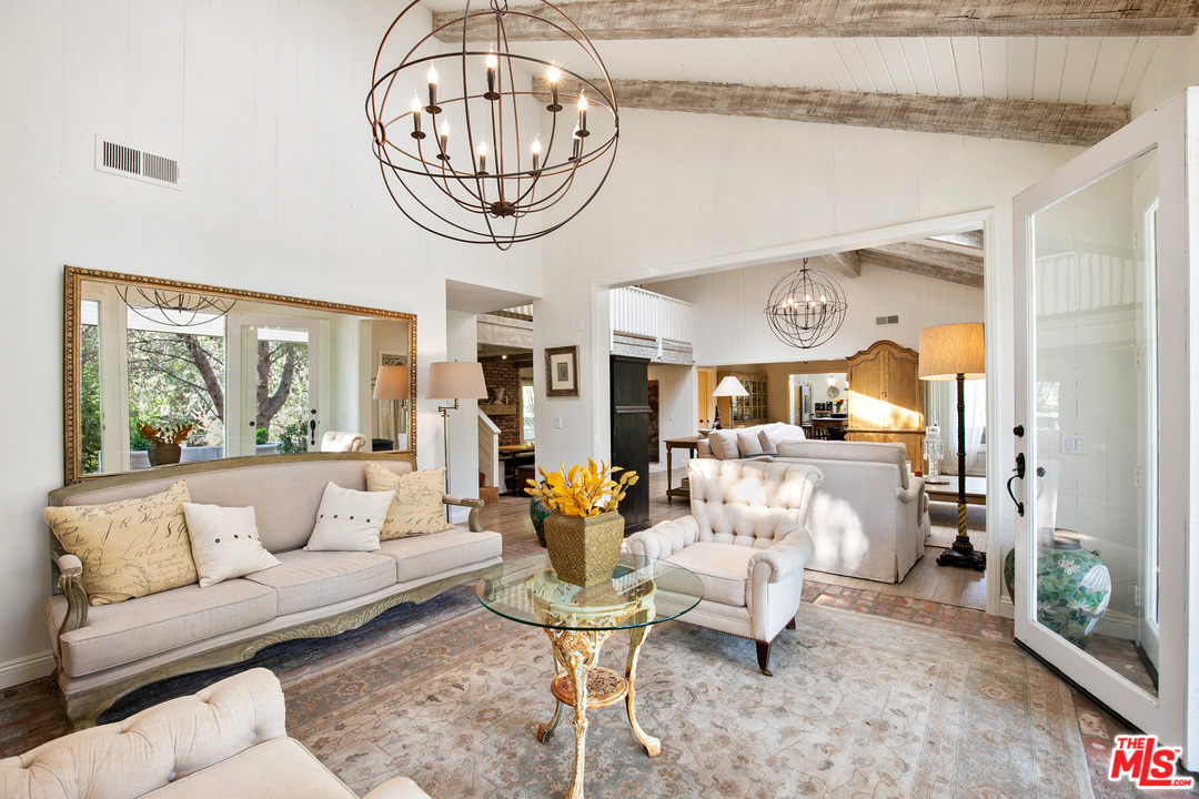 6133 Ramirez Canyon Road Malibu, CA 90265 - Photo 8 of 53 a living room with furniture a rug and a chandelier